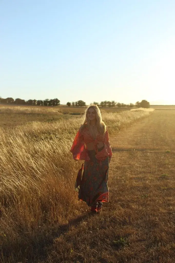 Indiana walking along a field path at golden hour.